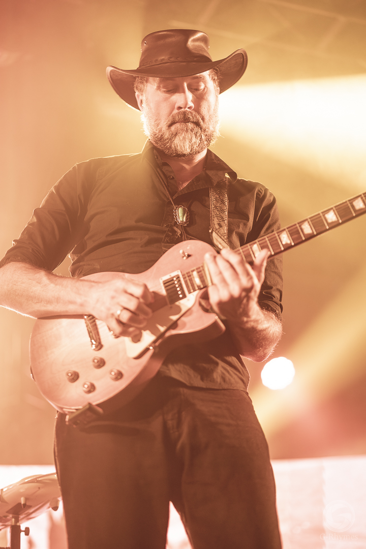 Guitarist in a cowboy hat backlit by orange stage beams, Midtown Ballroom
